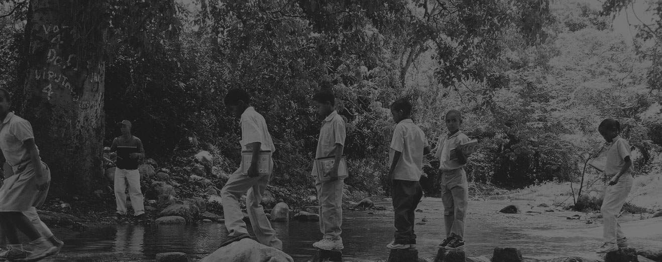 6 écolieris et un adulte traversant une rivière en République dominicaine