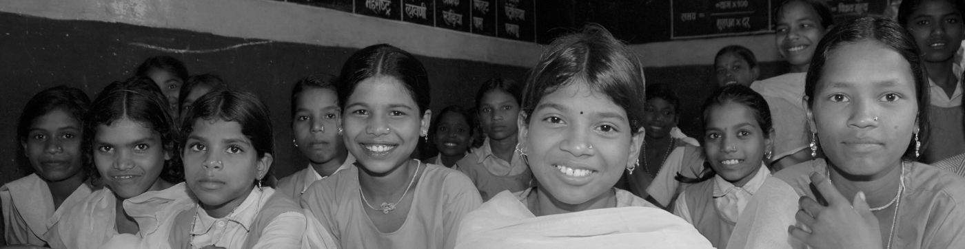 Groupe de filles assises en tailleur dans une classe en Inde
